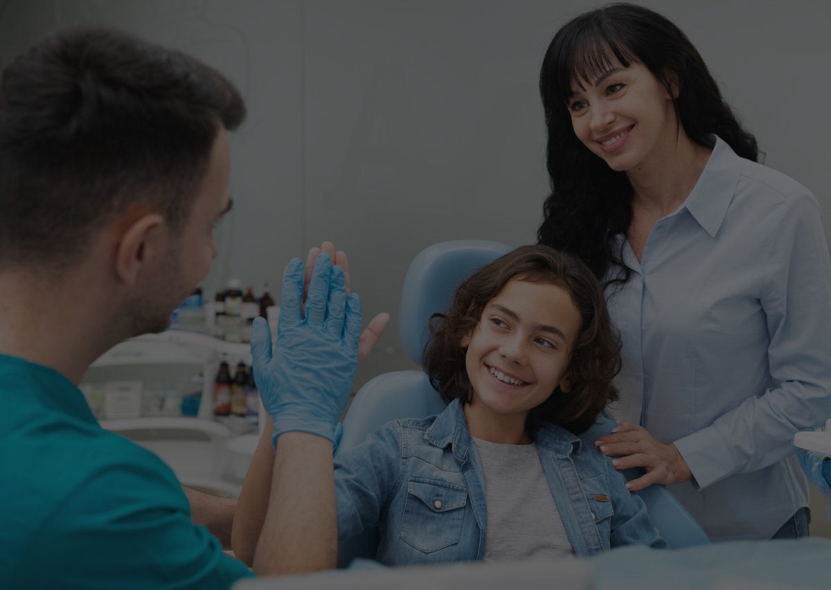 Young patient high-fiving her dentist after a check-up at Dental Quest, Dwarka